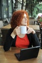 Businesswoman drinks a tea and working outdoors