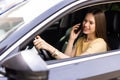 young woman driving car and talking on cell phone concentrating on the road