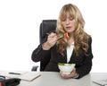 Businesswoman eating salad at her desk Royalty Free Stock Photo