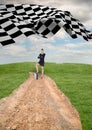 businesswoman at the end of the road with the checker flag in the start of the same road. Royalty Free Stock Photo