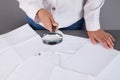 Businesswoman examines office documents with a mgnifying glass Royalty Free Stock Photo