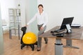 Businesswoman Exercising With Pilates Ball On Chair