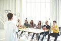 Businesswoman explain ideas to group of creative diverse team at modern office. Rear view of manager gesturing hand standing again