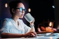 Businesswoman in eyeglasses holding cup while working late in office Royalty Free Stock Photo