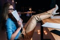 Businesswoman in eyeglasses holding newspaper while working late in office Royalty Free Stock Photo