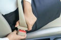 Businesswoman fastening seat belt in car before driving