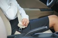 Businesswoman fastening seat belt in car before driving