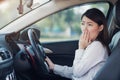 Businesswoman feel tried and sleepy in a car