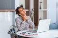 Businesswoman feeling pain in neck after sitting at the table with laptop. Tired female suffering of office syndrome because of Royalty Free Stock Photo