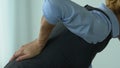 Businesswoman feels acute back pain after work in office, sedentary lifestyle