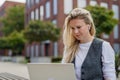 Businesswoman, freelancer or manager working outdoors in city park. Woman with laptop on knees sitting on park bench Royalty Free Stock Photo