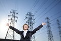 Businesswoman in front of power lines with arms oustretched Royalty Free Stock Photo