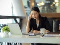 A businesswoman gets a headache while trying to solve problems at work