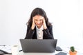 Businesswoman gets headache during working on laptop computer at office. Working woman do her work many hours, doesnÃ¢â¬â¢t take rest