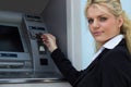 Businesswoman getting money from credit card at ATM