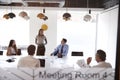 Businesswoman Giving Boardroom Presentation Viewed Through Meeting Room Window Royalty Free Stock Photo