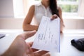 Businesswoman Giving Cheque To Colleague Royalty Free Stock Photo
