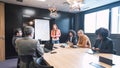 Businesswoman giving presentation to diverse colleagues in conference room Royalty Free Stock Photo