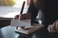 Woman giving and showing an empty business card while writing down on a notebook Royalty Free Stock Photo