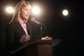 Businesswoman Giving Speech At Podium In Auditorium