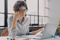 Businesswoman in glasses feeling tired, suffering from eye strain and fatigue during computer work