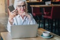 Businesswoman in glasses is sitting at table in front of laptop Royalty Free Stock Photo