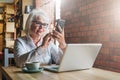 Businesswoman in glasses is sitting at table in front of laptop and using smartphone.Education for adults. Freelancer Royalty Free Stock Photo