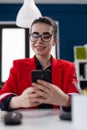 Businesswoman with glasses in videocall conference using smartphone.