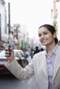 Businesswoman Hailing Taxi On Street