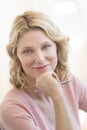 Businesswoman With Hand On Chin Smiling In Office