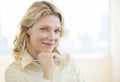 Businesswoman With Hand On Chin Smiling In Office