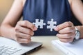 Businesswoman Hand connecting couple puzzle piece in office. Business solutions, mission, successful, goals and strategy concepts Royalty Free Stock Photo