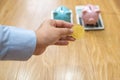 Businesswoman hand holding bitcoin with piggybanks and calculator behind Royalty Free Stock Photo