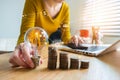 Businesswoman hand holding lightbulb with using calculator and laptop computer and money stack in office. Royalty Free Stock Photo