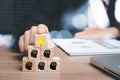 Businesswoman hand holding llight bulb and people icon on wooden cube with copy space