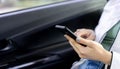 Businesswoman hand holding smartphone to checking job and reading mail inside car Royalty Free Stock Photo