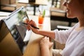 Businesswoman hand pointing with stylus on the chart over convertible laptop screen in tent mode. Woman using 2 in 1 Royalty Free Stock Photo