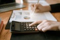 Businesswoman hand pressing on calculator for calculating cost estimating