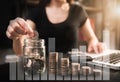 Businesswoman hand puting coins in glass for saving money. concept finance and accounting.