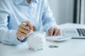 Businesswoman hand putting coin into piggy bank, step up start up business to success, Saving money for future plan and retirement Royalty Free Stock Photo