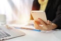 Businesswoman hands in black suit sitting and using mobile phone. Woman working or using computer on white table in modern office Royalty Free Stock Photo