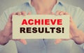 Businesswoman hands holding card sign with achieve results message