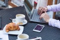 Businesswoman hands with laptop and mobile phone during breakfast. Royalty Free Stock Photo