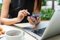 Businesswoman hands using mobile phone with laptop computer and snack on desk. Work from home, business and technology concept. Royalty Free Stock Photo