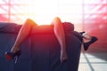 Businesswoman hanging long legs in office