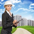 Businesswoman in hard hat, writing on clipboard Royalty Free Stock Photo