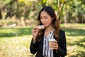 A businesswoman is having a quick breakfast in a city park, eating a sandwich and drinking coffee Royalty Free Stock Photo