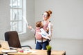 Businesswoman with her baby son working with documents at the office Royalty Free Stock Photo