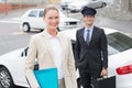 Businesswoman and her chauffeur smiling at camera