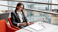 Businesswoman at her workplace reads information on a tablet. A woman works with documents and searches for insights on the